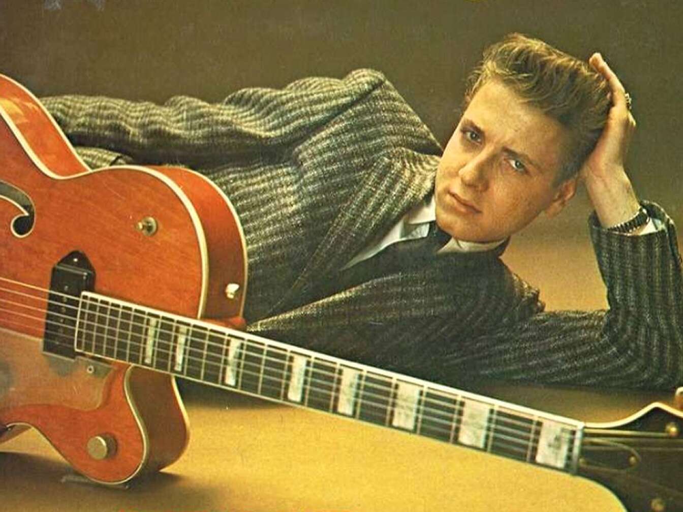 Eddie Cochran bei einem Presseshooting mit seiner Gitarre auf dem Boden liegend