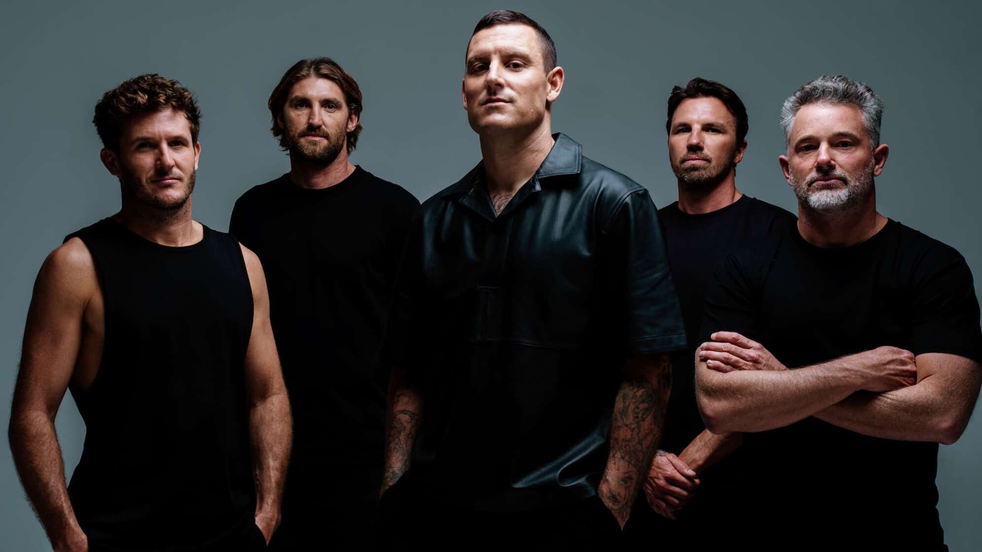 Die Bandmitglieder von Parkway Drive vor einem grauen Hintergrund